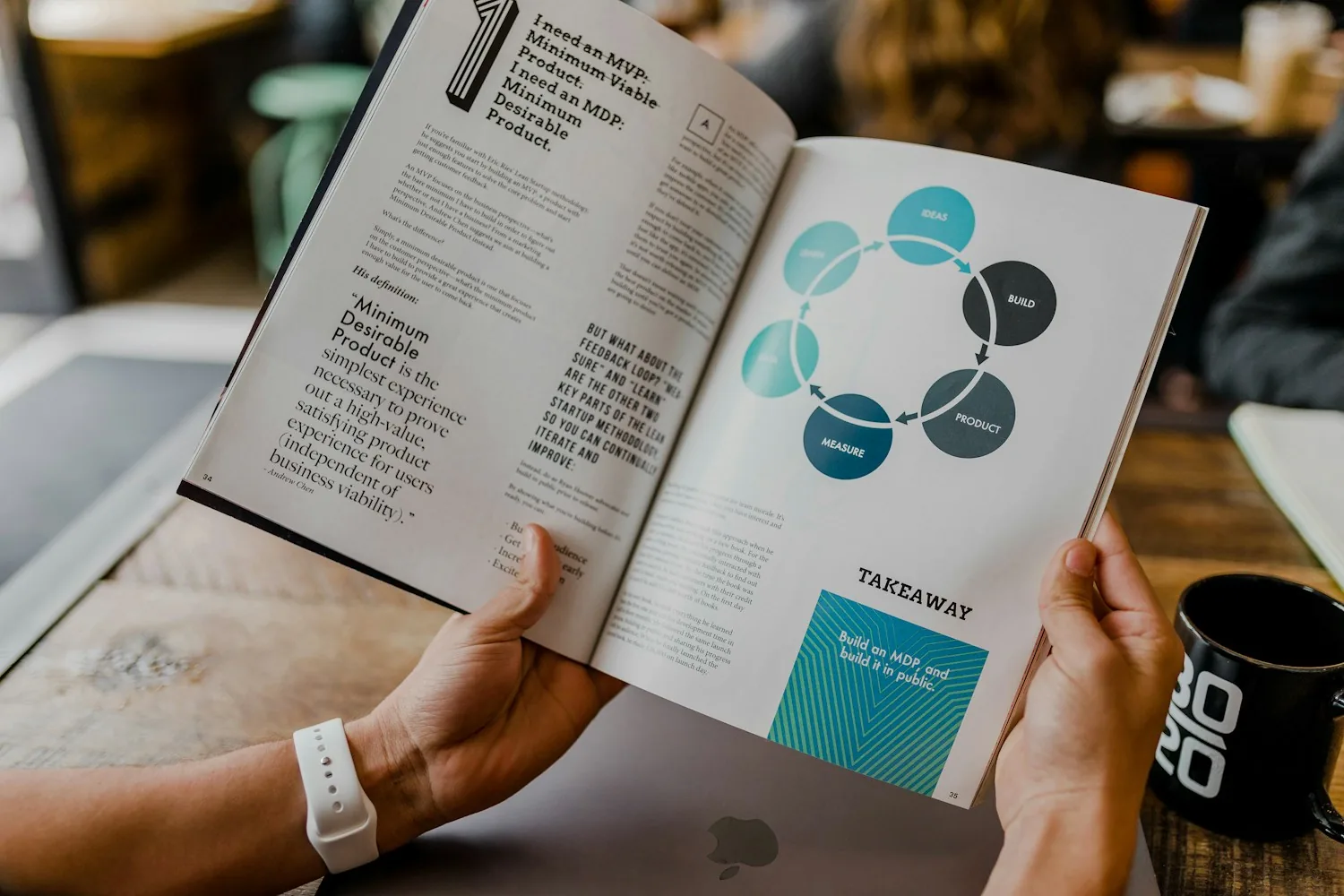 Person photographing a book arranged on a tabletop