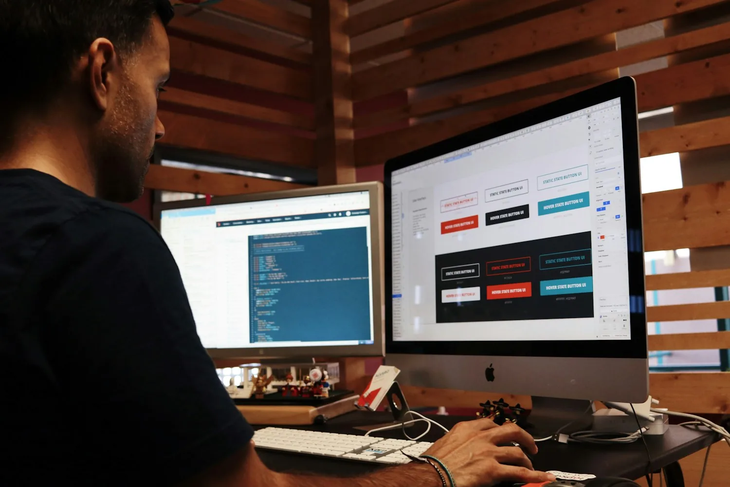 Person working across two computer monitors at a desk